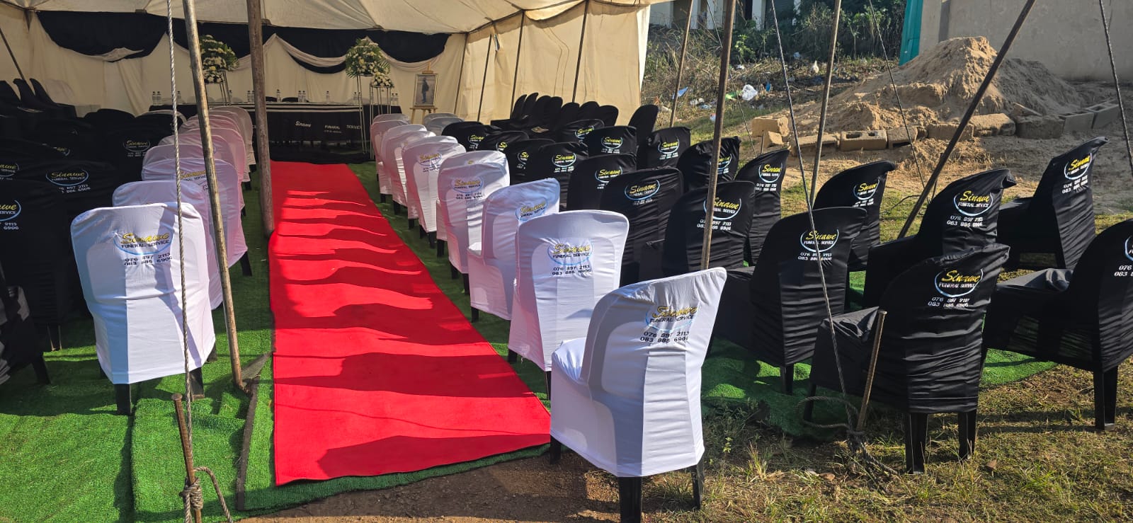 Black and white covered chairs with a red carpet aisle
