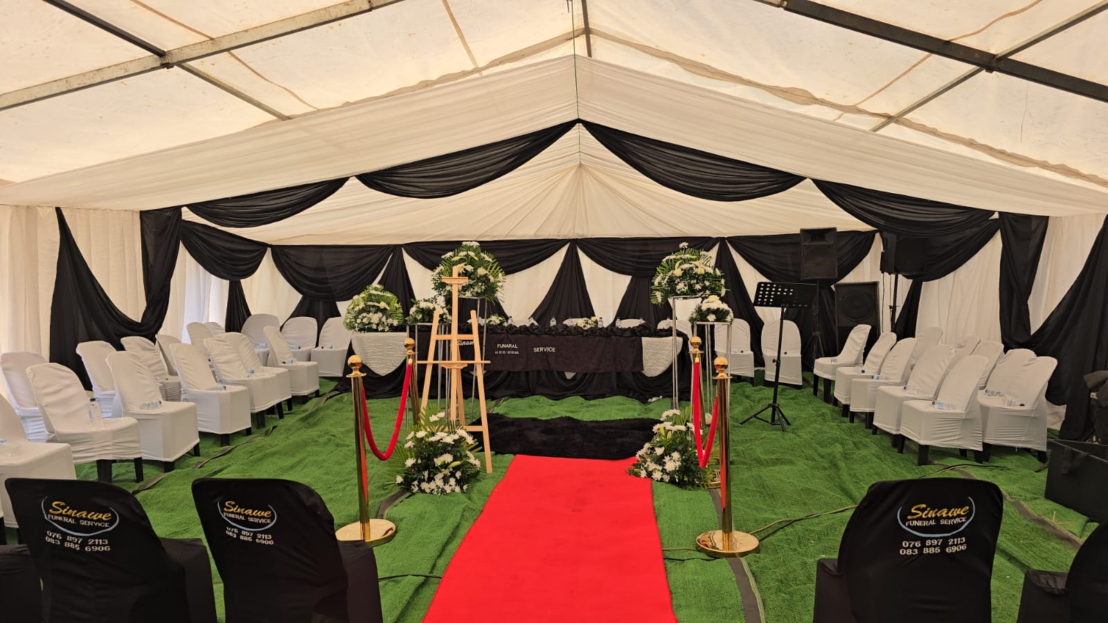 Sinawee Funeral Service draped tent with red carpet and white chairs