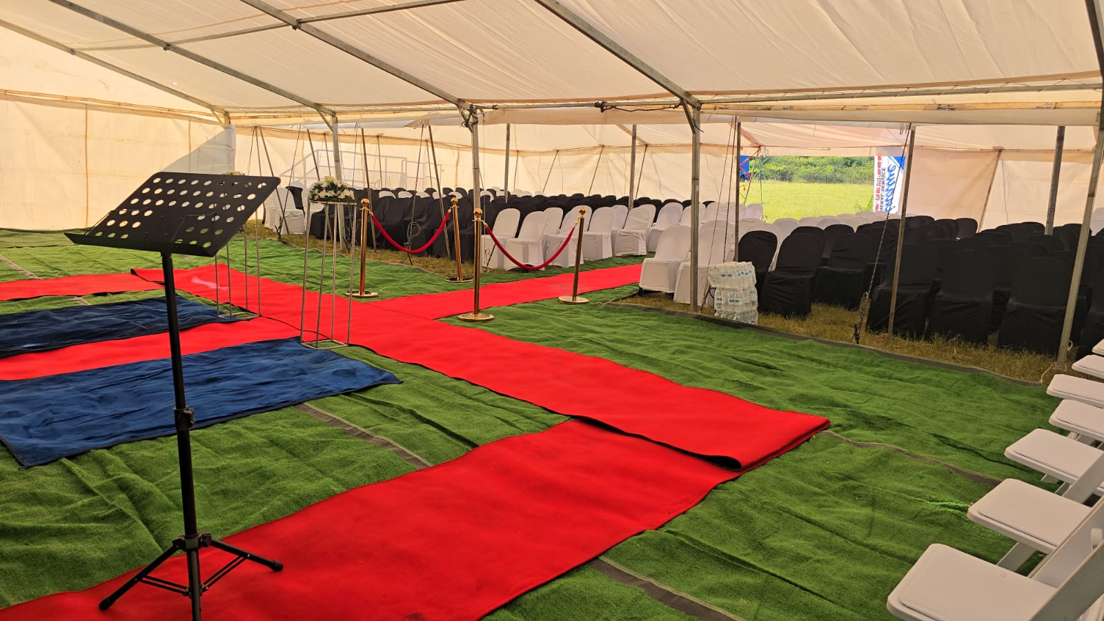 Red carpet walkway and music stand inside the funeral tent