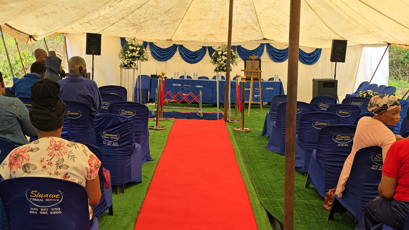 Sinawee Funeral Service tent with draped seating and red carpet